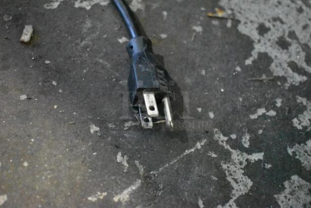 An electrical plug on a worn, concrete surface.
