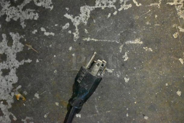 Close-up of a power plug for Manitowoc SD0452A Ice Machine, attached to a worn, textured surface.