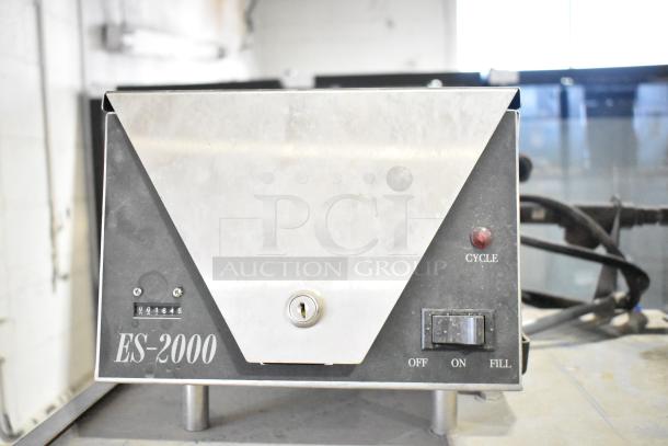 Ecolab ES-2000 commercial dishwasher, straight pass-through design, cycle dial, on/off switch, serial number visible.