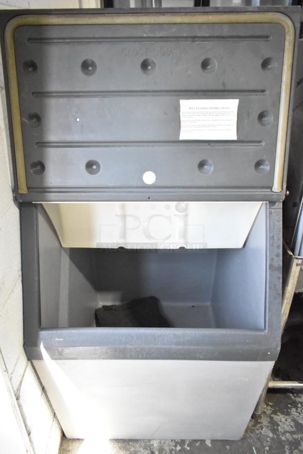 Scotsman Commercial Ice Bin open, showing storage interior. Black and gray finish, includes cleansing instructions label.