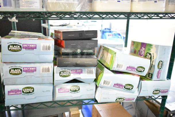 Two-tier shelf with boxes of Black Forest Juicy Burst gummies and Starbucks coffee pods. Items in original packaging.