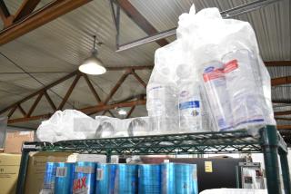 Three-tier shelving with Ajax Heavy Duty Formula Cleaner and Diversey Oxivir Sanitizer, packed in plastic.