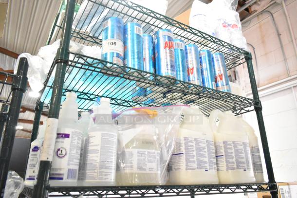 Three-tier shelf with Ajax Heavy Duty Cleaner cans and Diversey Oxivir Sanitizer bottles. Items labeled, auction lot 106.