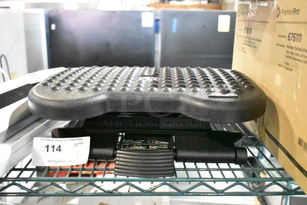 Textured black footrest on shelf with auction label "114." Features non-slip surface and adjustable mechanism.