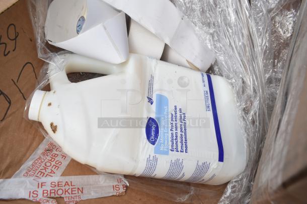A box of mixed items including Diversey ProX cleaner with white bottles and visible "If Seal is Broken" tape.