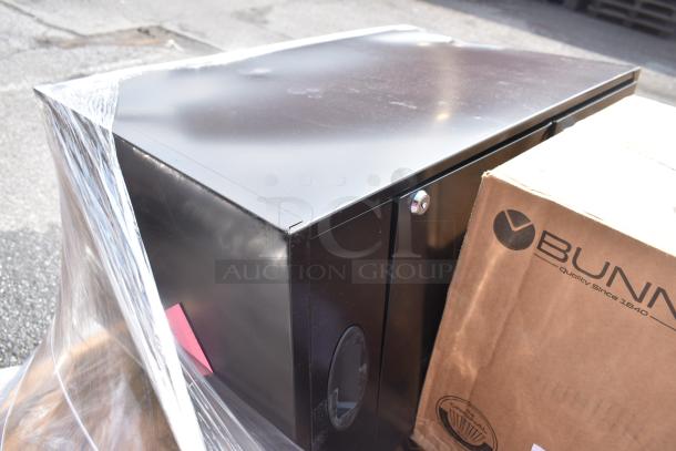 Black metal filing cabinet, securely wrapped. Includes boxed Bunn items. Scratch and dent condition, sold in bulk.