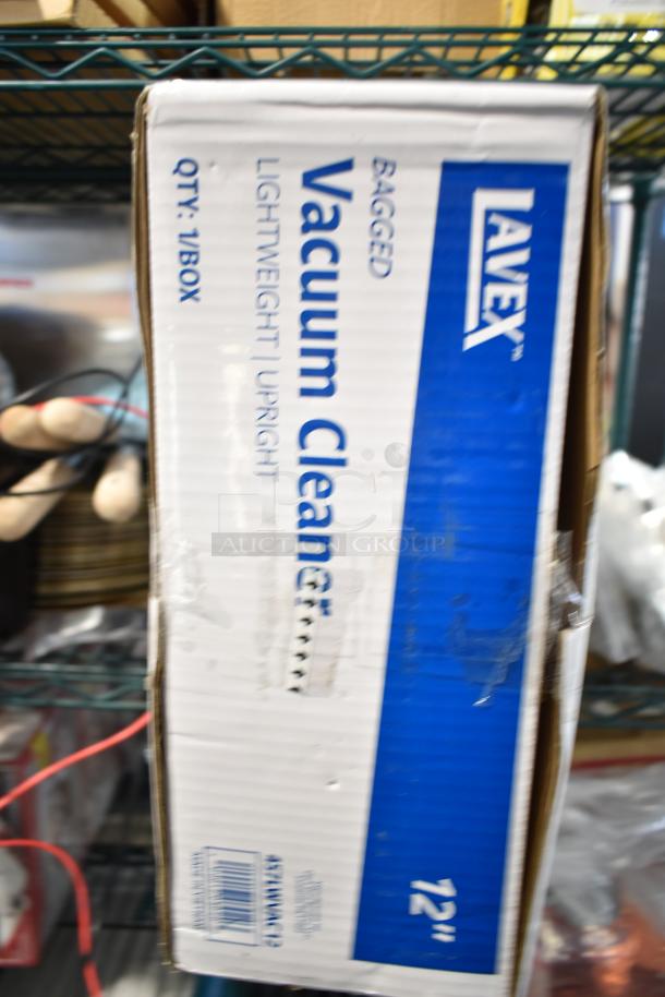 Box of Lavex 457LWVAC12 12" lightweight upright bagged vacuum cleaner. Brand new with visible scratches and dents.