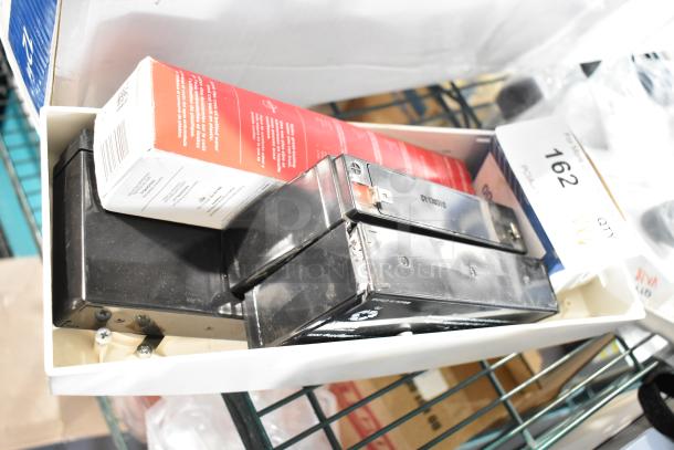 6 new scratch and dent items, including 940-0001-61 Relay, Hubbell battery, in packaging. Auction lot 162 label visible.