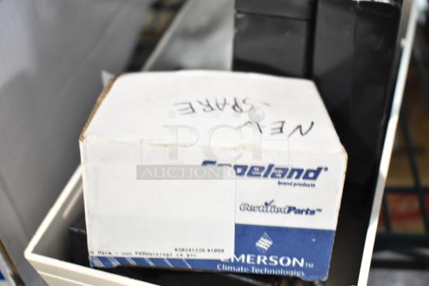 6 new scratch and dent items, including Copeland box and Hubbell battery. Tags show part numbers and Emerson branding.