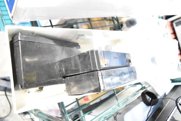 6 brand new scratch-and-dent items, including 940-0001-61 relay and Hubbell battery, on auction shelf.