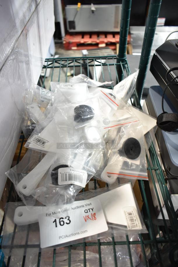 18 new scratch and dent items, including white plastic scrapers and black knobs, packaged in clear plastic bags. Auction label "163 QTY 18".