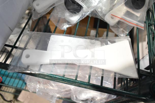 Alt text: "Set of brand new scratch and dent items including white scrapers and black knobs in sealed packaging."