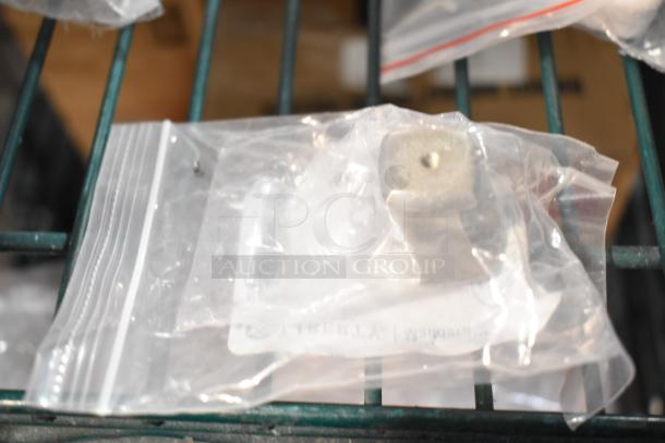 Sealed plastic bag containing a square metal knob, part of a lot of 18 new scratch and dent items.