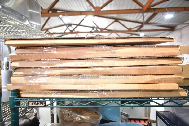 Stack of eight new Willscot calendars in cardboard packaging with minor cosmetic imperfections, on a metal shelf.