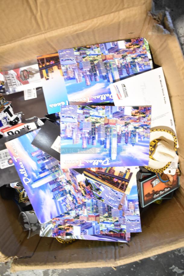 Boxed lot including Texas-themed postcards, pins, a spoon, shot glasses, and various memorabilia. Dallas images visible.