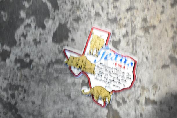 Texas-shaped plaque with Texas imagery, including a longhorn, Alamo, and armadillo, and state facts printed on it.