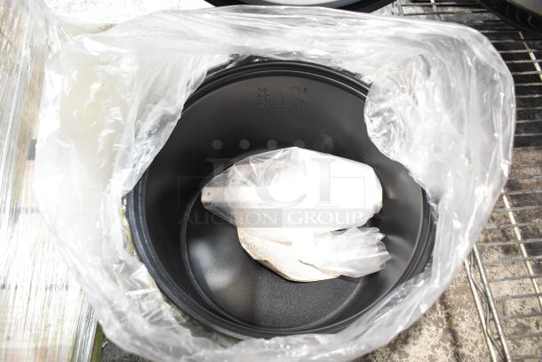 Galaxy 177RCSG60 rice cooker interior, new condition, with measuring cup and paddle, wrapped in plastic.