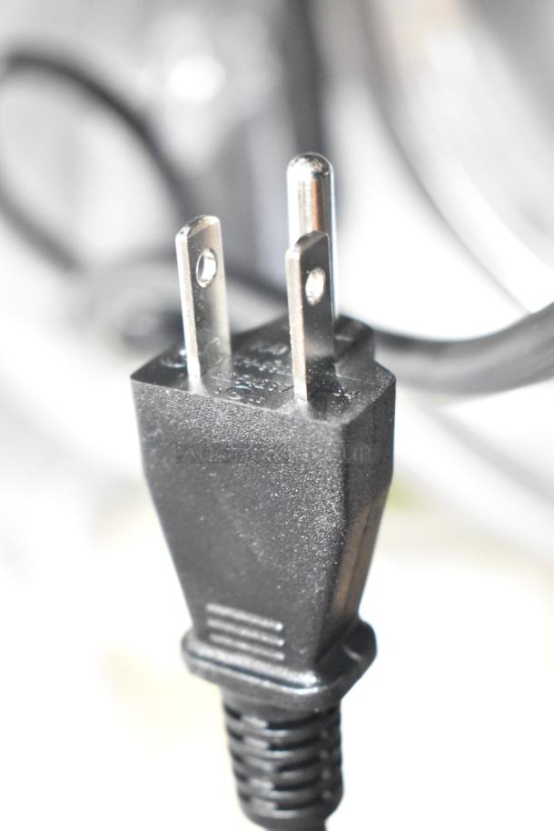 Close-up of a black power plug for the Galaxy 177RCSG60 rice cooker, showing prongs and cord texture.