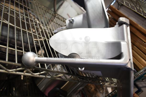 Commercial pelican head with grating blade on metal rack, showing sturdy construction and a smooth handle for kitchen use.