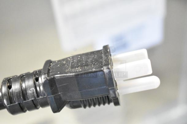Close-up of Avantco 177HPI1836 power plug, showing a three-prong connector and black housing, part of heated cabinet unit.