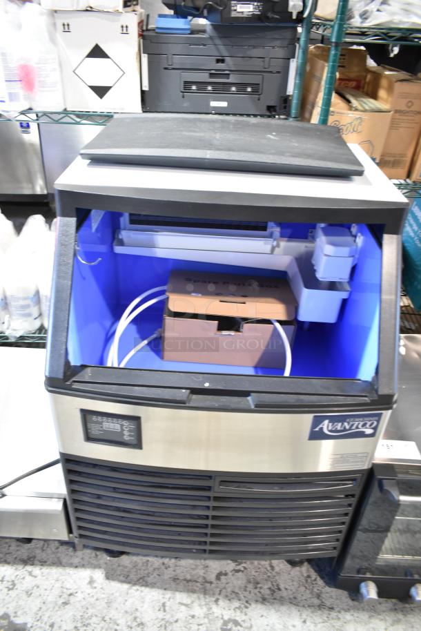 Brand new Avantco commercial ice machine, scratch and dent condition, self-contained unit with visible spare parts box inside.