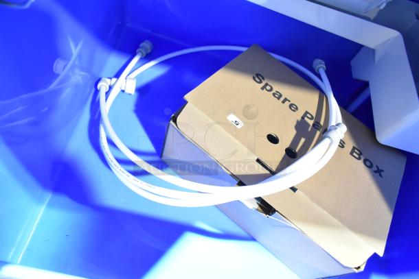 Avantco self-contained ice machine inside view, includes spare parts box and tubing. New condition with minor scratches.