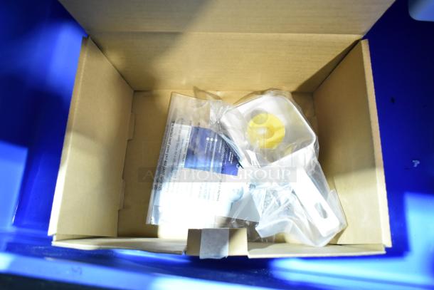 Alt text: Open cardboard box containing parts for Avantco ice machine, including a white scoop and plastic accessories in packaging.