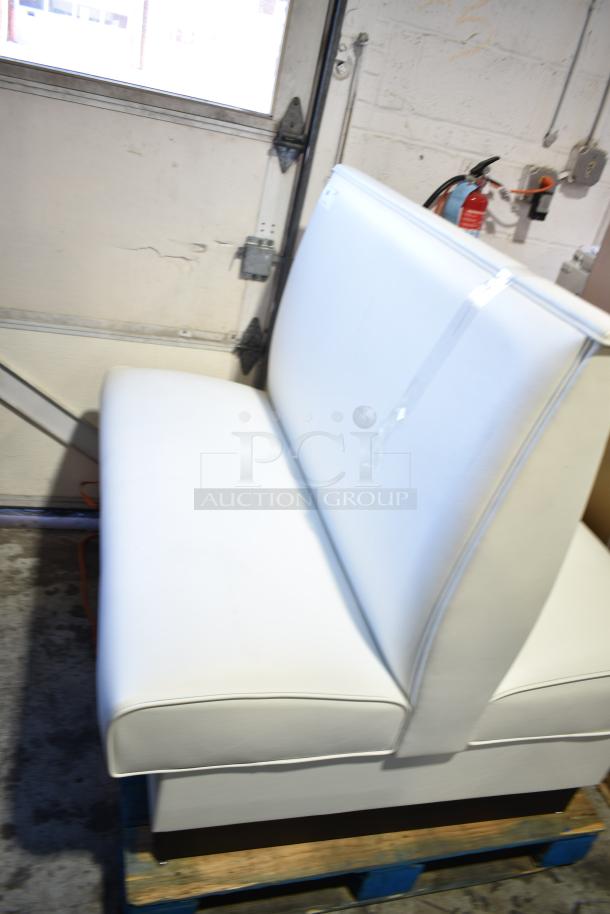 White double-sided booth seat with padded backrest and seat, minimal wear. Ideal for restaurant or cafe seating.