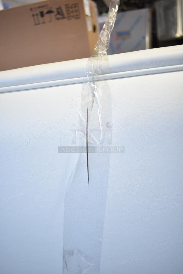 White double sided booth seat with visible wear and tear; taped seam indicating existing damage; textured upholstery.