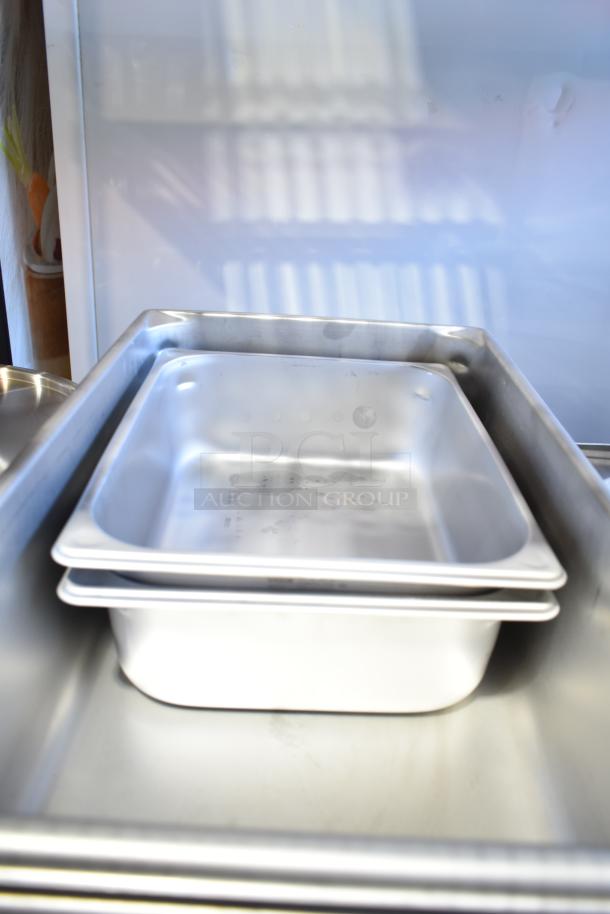 Set of brand new, scratch and dent stainless steel steam table pans, various sizes, with anti-jam features.