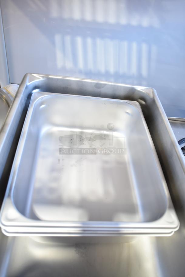 Stack of new aluminum perforated and stainless steel steam table hotel pans, various sizes and gauges, scratch and dent condition.