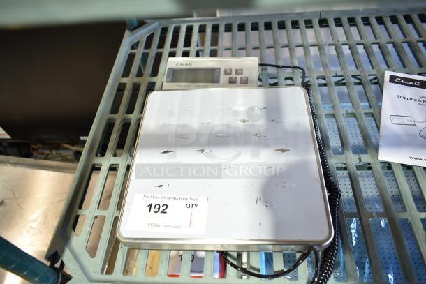 Brand new Escali 120S countertop scale with minor scratches. Includes digital display and manual. Lot tag visible.