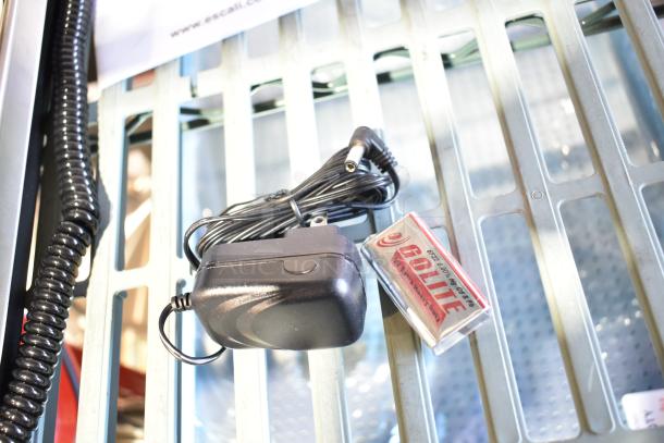 BRAND NEW SCRATCH AND DENT! Escali 120S countertop scale shown with power adapter and battery, minor scratches visible.