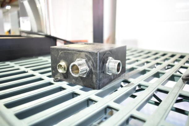 Black power unit model 020237-45, featuring multiple connectors, in used condition on a metal grate surface.