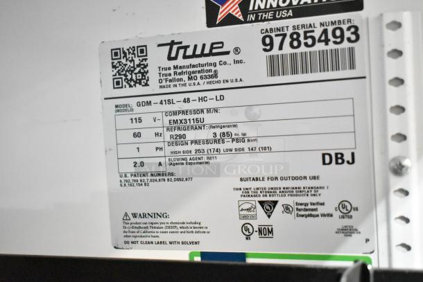 Label on a True GDM-41SL-48-HC-LD commercial cooler, model details, voltage, refrigerant type, and safety warnings visible.
