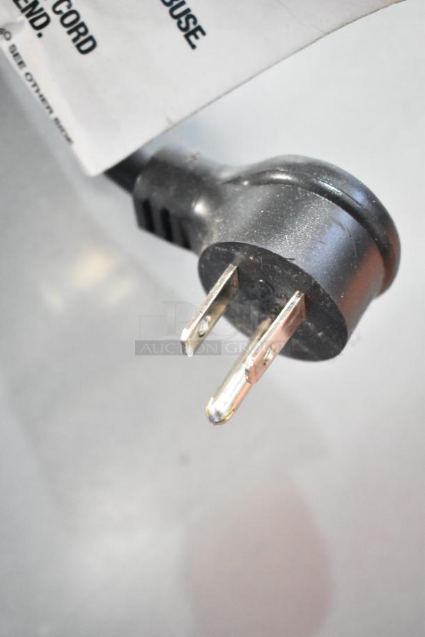 Power plug of Crane 5800-4 Metal Commercial Bottled Drink Vending Machine. Tag displays usage instructions.