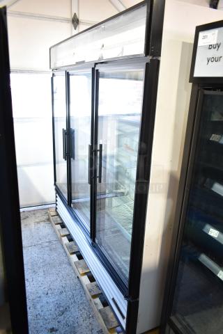 True GDM-72-HC-LD commercial three-door reach-in cooler, 115 volts, 1 phase, in good condition, showcasing glass doors and shelving.