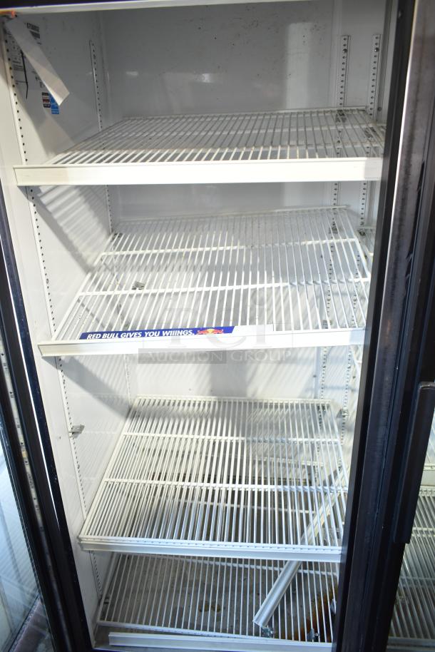 True GDM-72-HC-LD commercial 3-door cooler with five wire shelves, 115 volts, noted "Red Bull gives you wings" label inside.