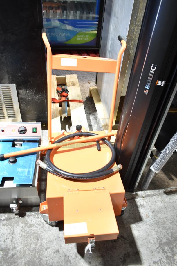 Brand new Fryclone 100 lb. fryer oil disposal unit, orange, with visible scratches and dents. Includes hose attachment.
