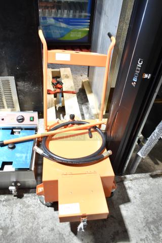 Brand new Fryclone 100 lb. fryer oil disposal unit, orange, with visible scratches and dents. Includes hose attachment.