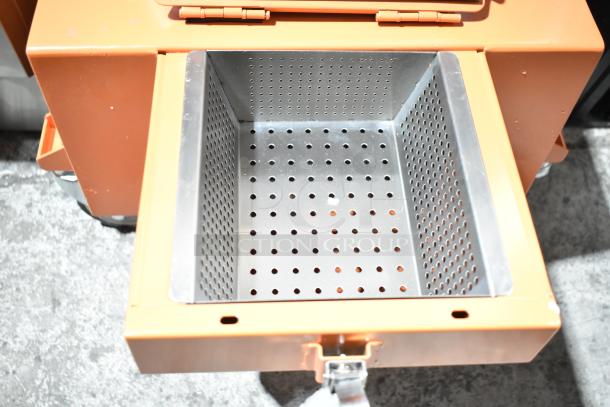 BRAND NEW SCRATCH AND DENT Fryclone 100 lb. Fryer Oil Disposal Unit with metal perforated interior, orange exterior.