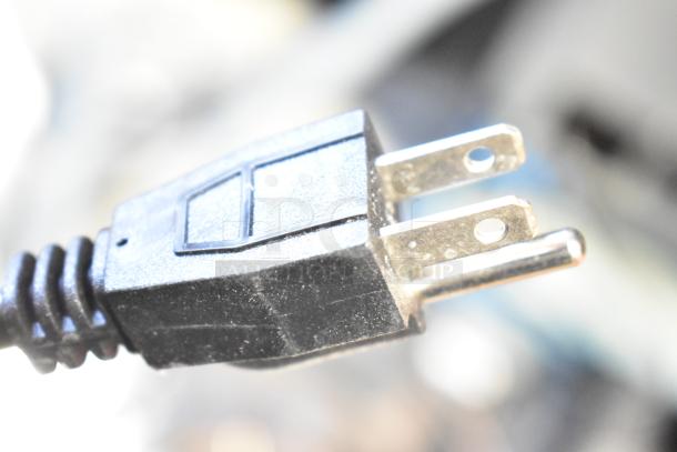 Close-up of a power plug for a 2025 Avantco 194UCH210A ice machine. Black plastic with two metal prongs.