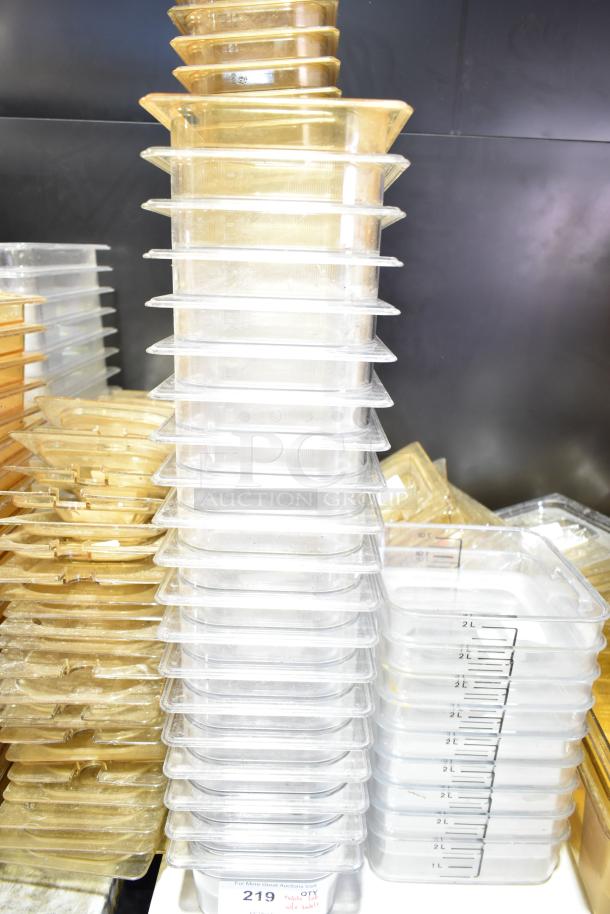 Stacked clear and amber plastic drop-in bins with lids, various sizes. Visible markings show volume measurements. Condition appears good.