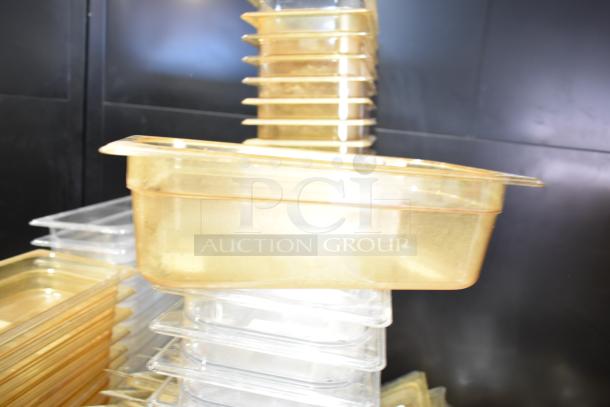 Lot of assorted plastic containers, drop-in bins, and lids in various sizes, stacked. Ideal for storage and organization.