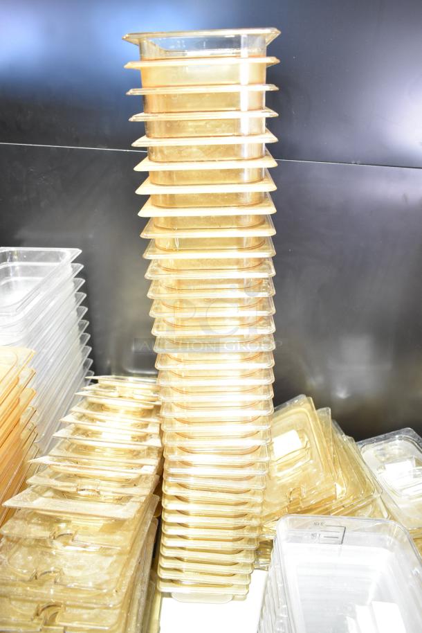 Lot of assorted plastic containers, drop-in bins, and lids. Includes stacks in clear and amber hues, visible light wear.