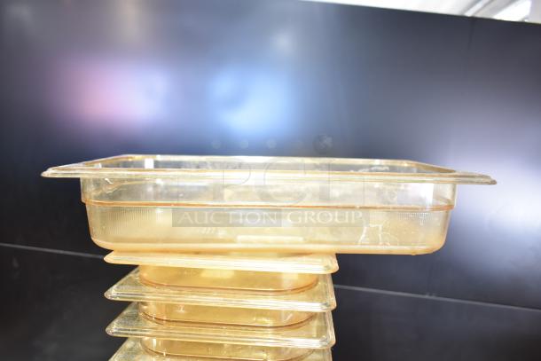 Stack of transparent plastic containers with lids, showing scratches and signs of wear. Ideal for storage or organization.