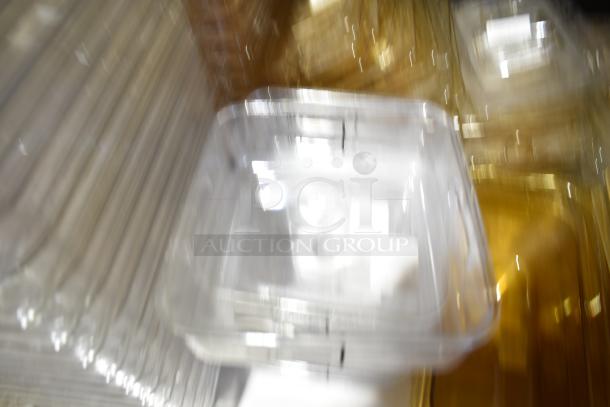 A blurry image of multiple clear and tinted storage containers stacked, including drop-in bins and lids.