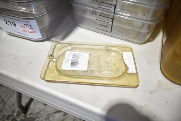 Lot of various containers, drop-in bins, and lids on a table. Includes items with visible measurement labels. Ideal for storage.