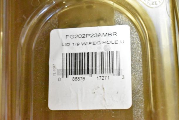 Lot of various items including containers, drop-in bins, and lids. Label reads "FG202P23AMBR LID 1/9 W/PEG HOLE U".