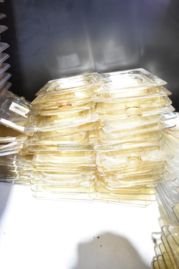 Stacked clear plastic lids, some with visible labels; part of a mixed lot with containers and drop-in bins.
